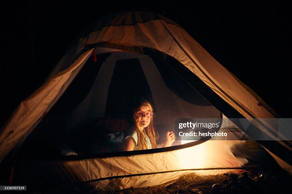 Girl inside tent at night