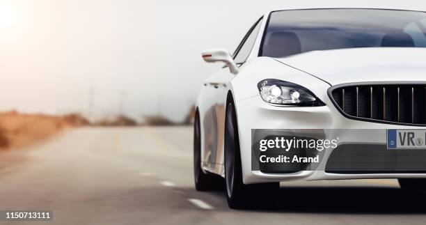 coche conduciendo por una carretera - expensive car fotografías e imágenes de stock