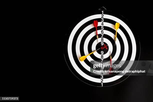 dart arrow hitting in the target center of dartboard,arrow on a black background - darttavla bildbanksfoton och bilder