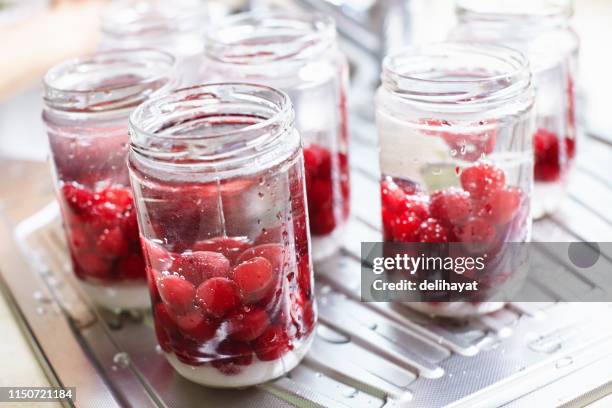 conserve di composta di ciliegie fatte in casa in barattoli per l'inverno in cucina - cherry foto e immagini stock