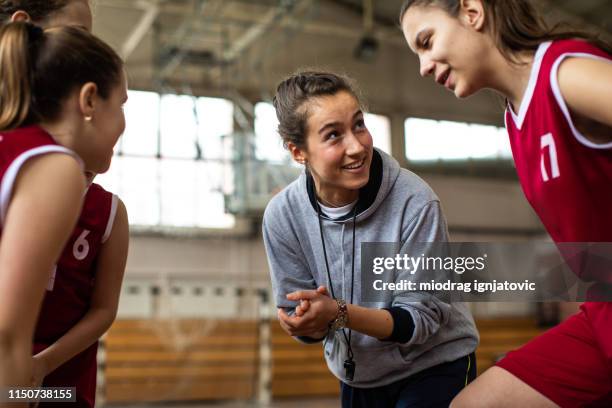 happy basketball team with their cheerful female coach - girls basketball team stock pictures, royalty-free photos & images