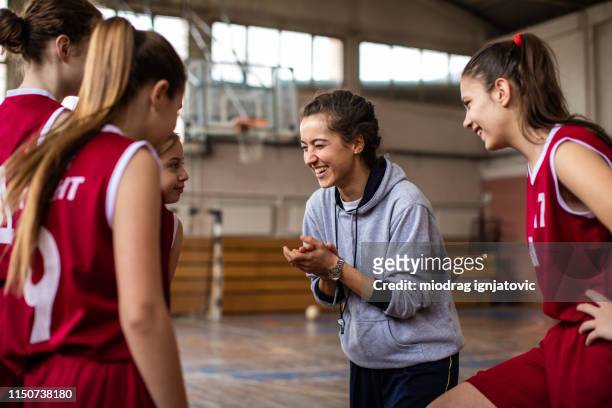 happy basketball team with their cheerful female coach - basketball sport team stock pictures, royalty-free photos & images
