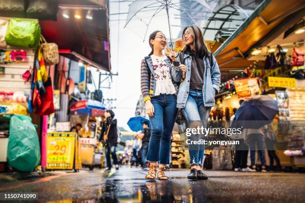 asiatiska tjejer som går på en gatu marknad - taipei bildbanksfoton och bilder