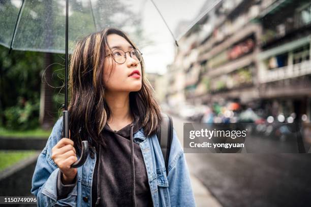 asian girl walking in street with an umbrella - chinese girl stock pictures, royalty-free photos & images