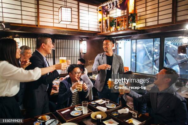 groupe de peuple japonais ayant le toast de célébration dans le pub de style japonais d’izakaya - saké photos et images de collection