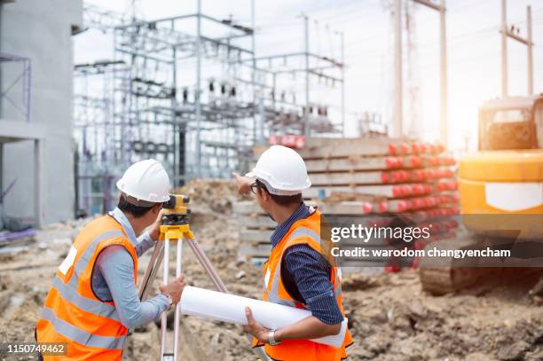 asian surveyor engineer making measure with partner on the field - image - land surveyor stock pictures, royalty-free photos & images