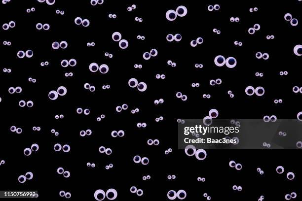 large group og googly eyes on black background - comic augen stock-fotos und bilder