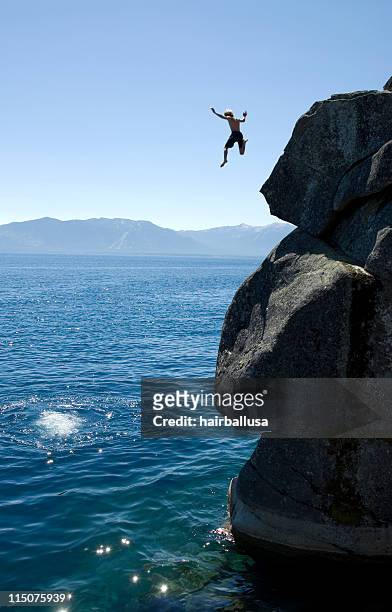 man jumping off a cliff into the sea - leap of faith stock pictures, royalty-free photos & images