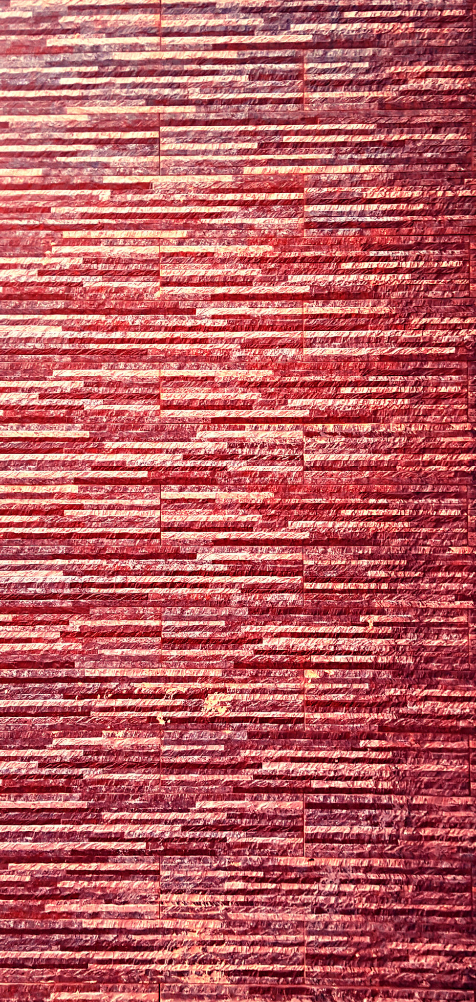 Picturesque, colorful and elegant facing of the wall of the fence, made of bonded thin plates of artificial granite, marble or other stone-forming material Picturesque, colorful and elegant facing of the wall of the fence, made of bonded thin plates of artificial granite, marble or other stone-forming material