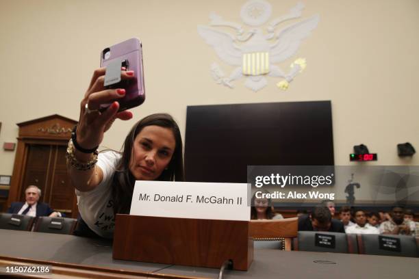 Alethea Shapiro of Long Island, New York, takes a selfie with the empty seat for White House Counsel Don McGahn at the witness table prior to a House...