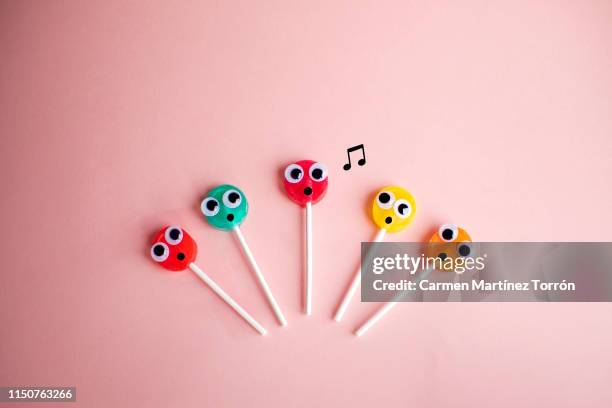 lollipops with cartoon eyes singing karaoke. - concert face stock pictures, royalty-free photos & images