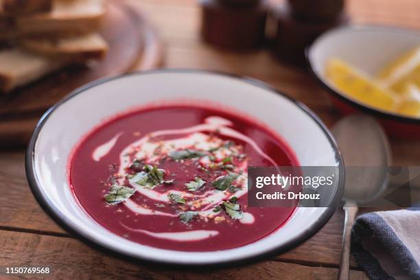 rote bete suppe mit joghurt auf dem tisch - rote rübe stock-fotos und bilder