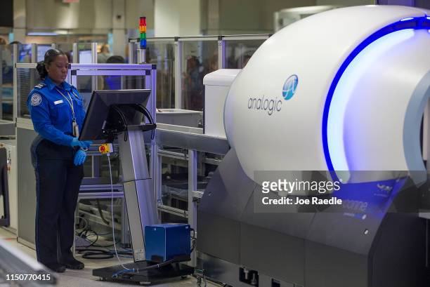 Transportation Security Administration agent, Roselie Pierre, keeps an eye on the 3-D scanner screen at the Miami International Airport on May 21,...