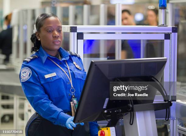 Transportation Security Administration agent, Roselie Pierre, keeps an eye on the 3-D scanner screen at the Miami International Airport on May 21,...