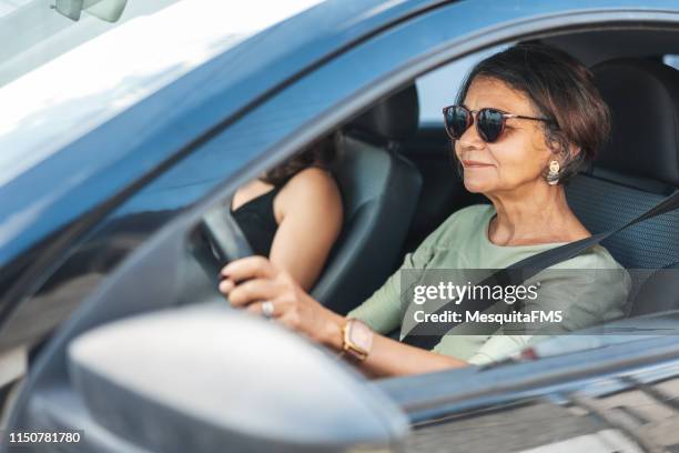 gelukkige rijpe vrouw het besturen van een auto - family inside car stockfoto's en -beelden