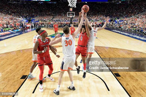 Jay Huff and Ty Jerome of the Virginia Cavaliers battle Kyler Edwards of the Texas Tech Red Raiders for a rebound during the 2019 NCAA Photos via...