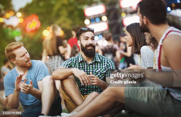 hanging out with friends before the concert. - music festival grass stock pictures, royalty-free photos & images