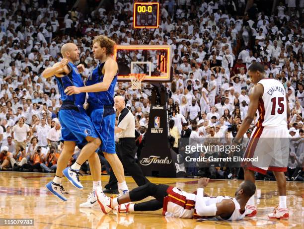 Jason Kidd and Dirk Nowitzki of the Dallas Mavericks celebrate as Dwyane Wade of the Miami Heat lays on the court after missing a last-second shot as...