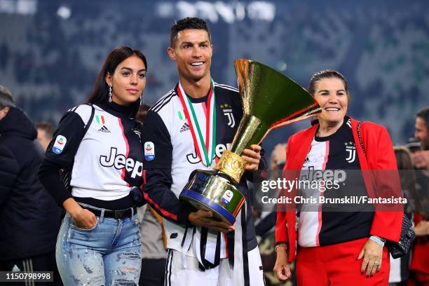 Cristiano Ronaldo of Juventus poses with the Serie A trophy alongside his girlfriend Georgina Rodriguez and mother Maria Dolores dos Santos Aveiro...