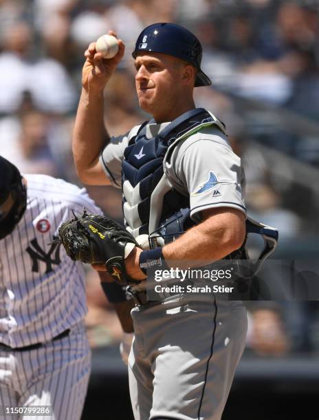 Erik Kratz of the Tampa Bay Rays holds up a ball during the second inning of the game against the New York Yankees at Yankee Stadium on May 18, 2019...