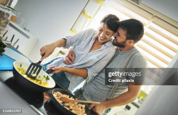 giovane coppia che cucina a casa. - utensile di portata foto e immagini stock