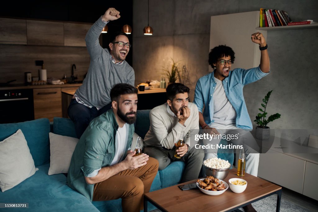 Vrienden kijken naar sport op TV.