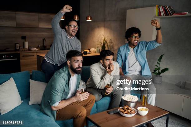 vrienden kijken naar sport op tv. - man watching tv on couch stockfoto's en -beelden