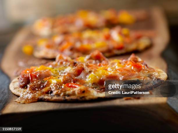 kleine tortilla pizzas mit wurst und pfeffer - tortilla flatbread stock-fotos und bilder