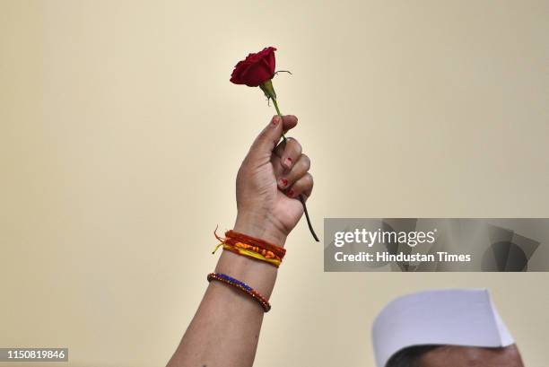 Congress party supporter holds a rose as she waits for Indian National Congress President Rahul Gandhi's arrival during his 49th birthday...