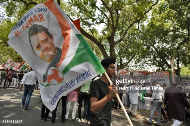 Congress party supporter holds a flag with the portrait of Indian National Congress President Rahul Gandhi during his 49th birthday celebrations,...