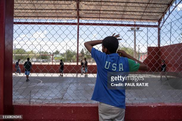 One of the residents of Iglesia Metodista "El Buen Pastor" migrant shelter watches the soccer match at a park near the shelter on June 09, 2019. -...