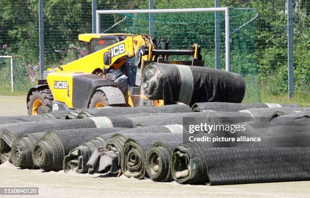 June 2019, Mecklenburg-Western Pomerania, Rostock: Old artificial turf is being removed from the Rostocker Wohnungsgesellschaft WIRO's "Damerower...