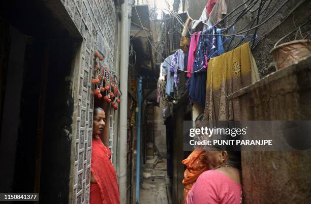 This picture taken on March 7, 2019 shows residents speaking in a narrow lane between their houses in Dharavi, Asia's largest slum in Mumbai. -...