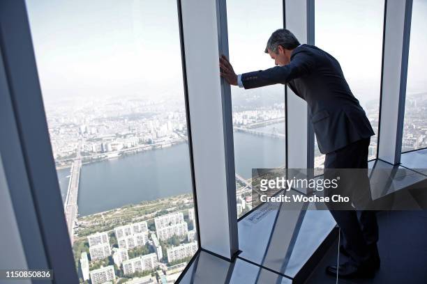 Crown Prince Frederik of Denmark walks on the glass floor and sees the view of Seoul at the observation deck on the 120th floor of Lotte World Tower,...