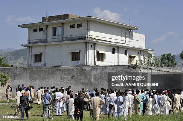 Pakistani media personnel and local residents gather outside the hideout of Al-Qaeda leader Osama bin Laden following his death by US Special Forces...