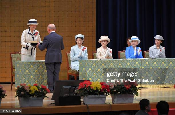 Empress Masako presents a certificate while Crown Princess Kiko of Akishino, Princess Hanako of Hitachi, Princess Nobuko of Mikasa and Princess...
