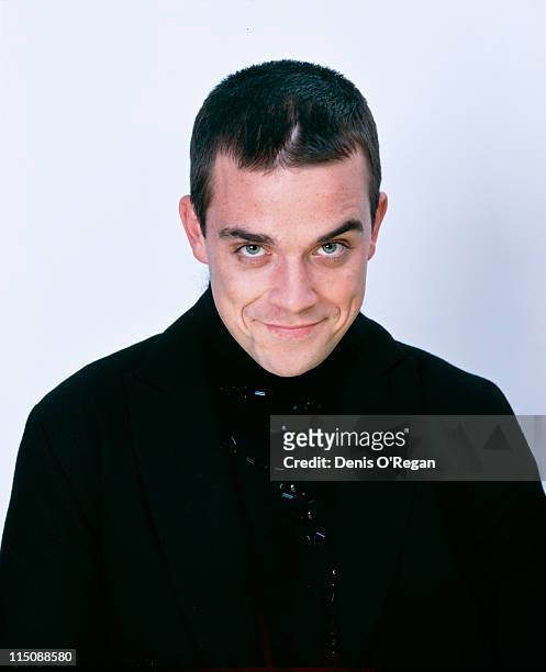 Studio portrait of singer songwriter Robbie Williams dressed in black, circa 1998.