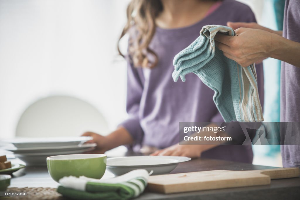 La mujer limpiando los platos en la cocina