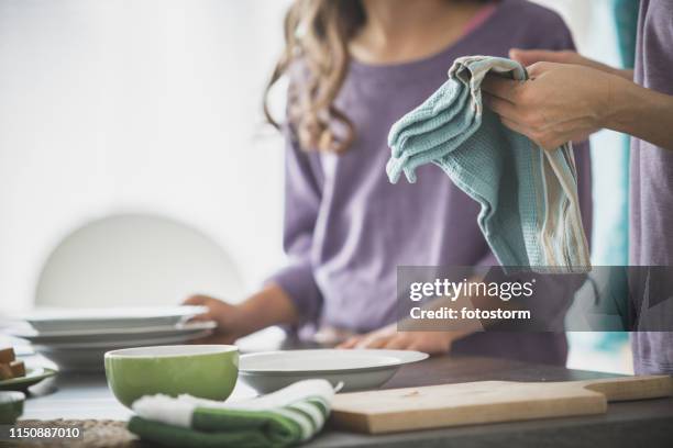vrouw schoonmaak gerechten in de keuken - theedoek stockfoto's en -beelden
