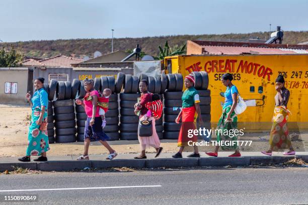 traditional dressed african ladies walking on the sidewalk of alexandra township, johannesburg - alexandra walker stock pictures, royalty-free photos & images