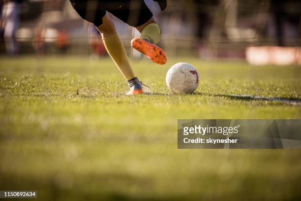 rear view van onherkenbaar voetbal goalie schoppen de bal. - verdediger voetballer stockfoto's en -beelden