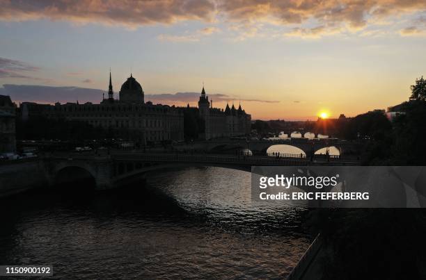 This picture taken on April 29, 2019 shows an aerial view of the banks of the Seine river in Paris at sunset with the Notre Dame Bridge, the...