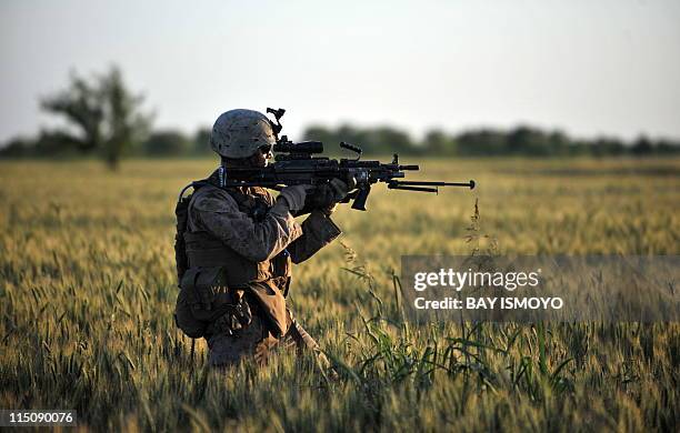 Marines Lance Corporal Michael Horne from Combat Operation Patrol Bandini of 2nd Marine 8 Batallion Weapons Company 81's Platoon gets ready to open...