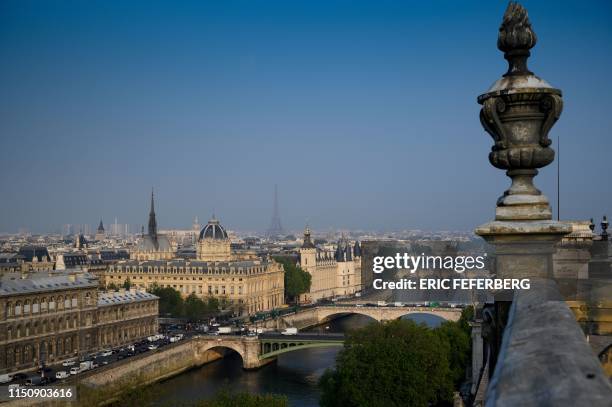 This picture taken at dawn on April 30, 2019 from the roof of the Hotel de Ville in Paris shows the Seine river banks, the Sainte-Chapelle, the...
