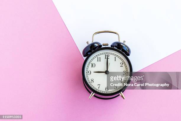 alarm clock on multi colored background - daylight saving time stock pictures, royalty-free photos & images