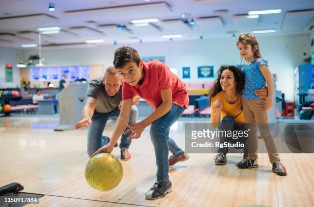 niño pequeño bowling con la familia - bowling alley fotografías e imágenes de stock
