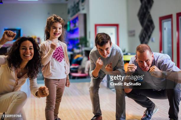aufgeregte junge familie - family bowling stock-fotos und bilder