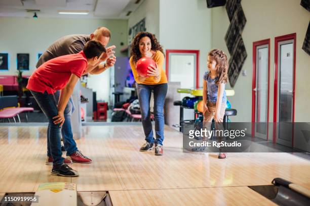 fröhliches familienunternehmen gemeinsam bowling - family bowling stock-fotos und bilder