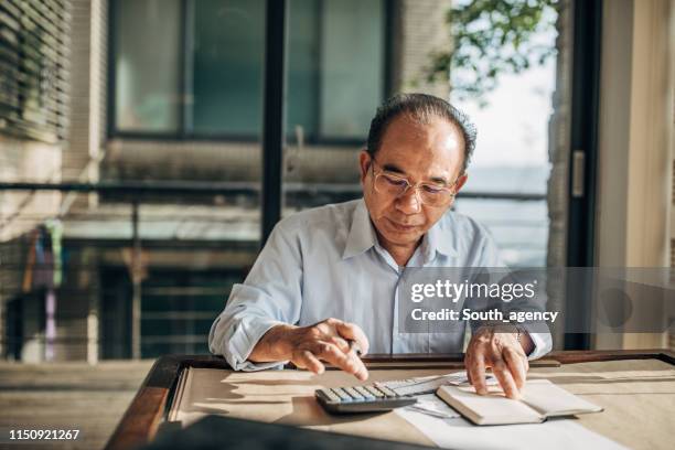 senior man doing finances at home - taxes stock pictures, royalty-free photos & images