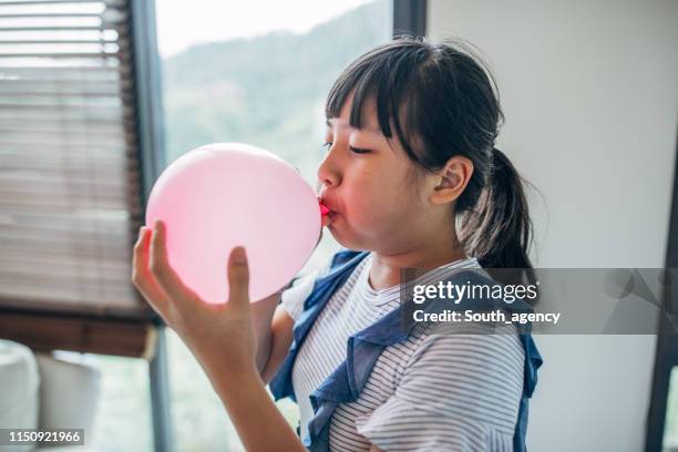 a menina infla o balão cor-de-rosa - inflating - fotografias e filmes do acervo